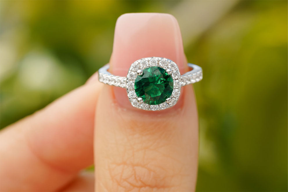 emerald engagement ring on finger