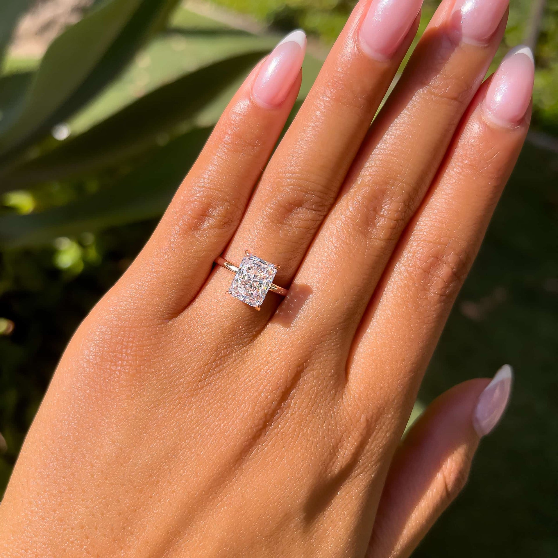 rose gold radiant cut solitaire engagement ring on model with french tip nails