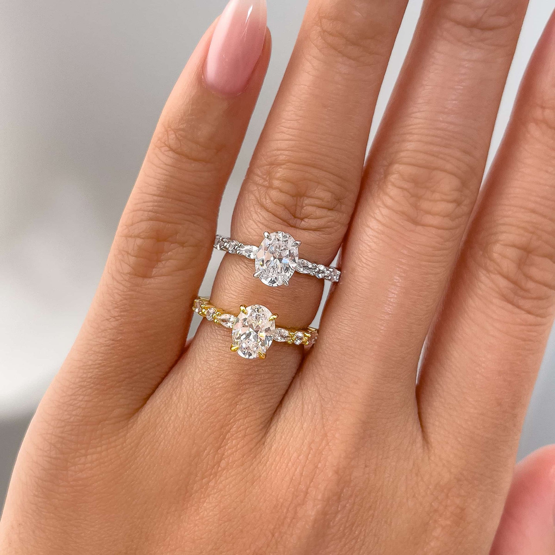 vintage style oval cut engagement ring shown in silver and gold on model