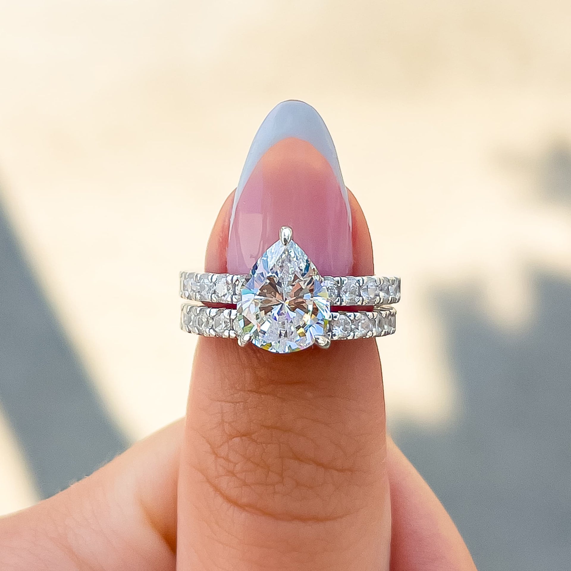 silver pear cut engagement ring paired with complementary silver wedding band