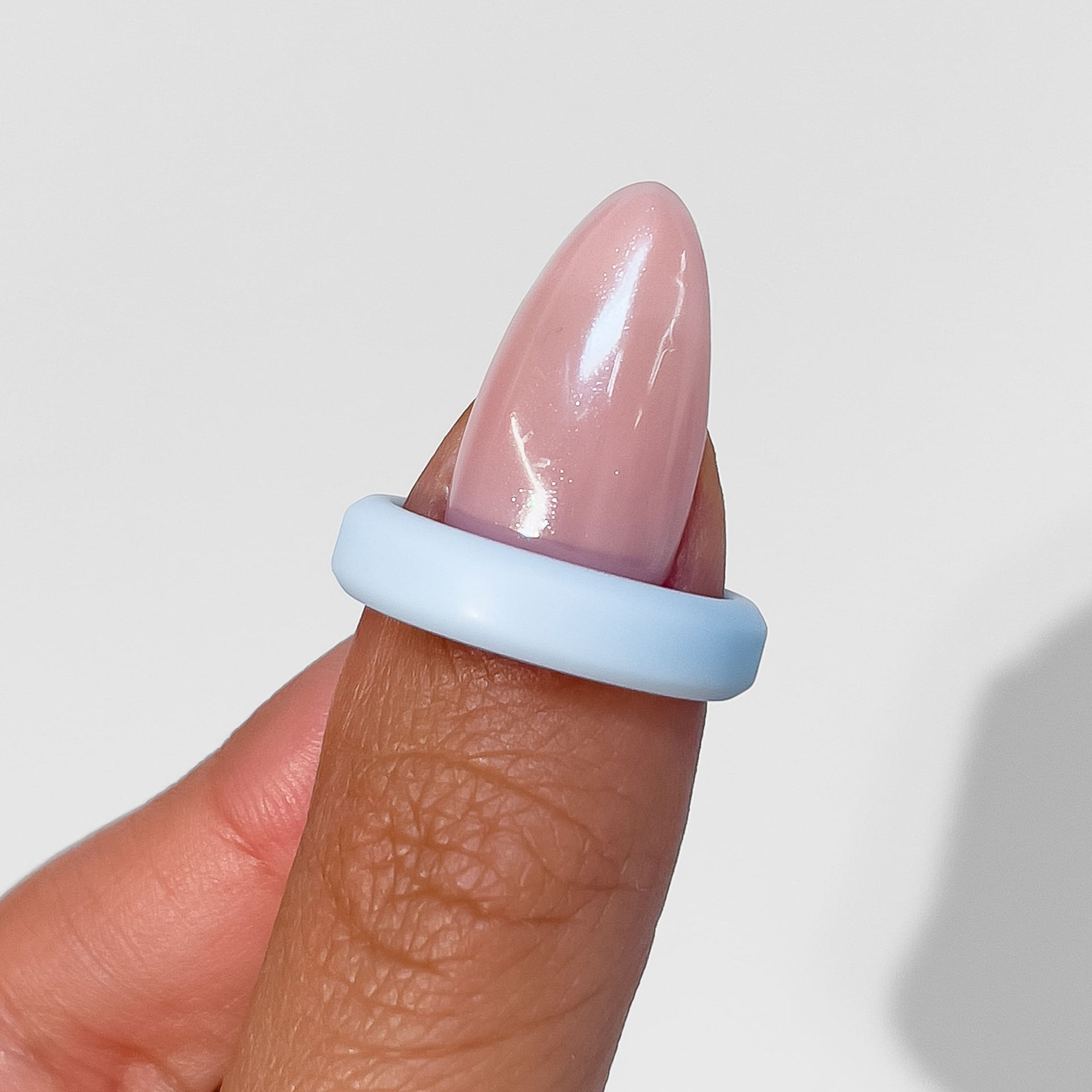 slim silicone unisex band in sky blue on female model with pink nails