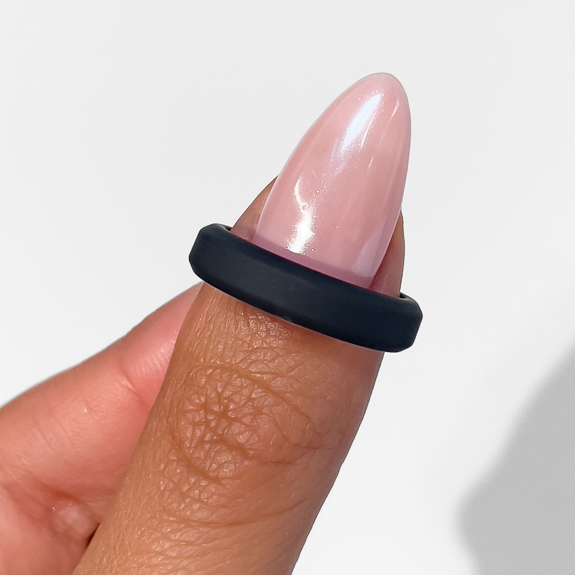 unisex silicone unisex band shown in black on female model with pink nails
