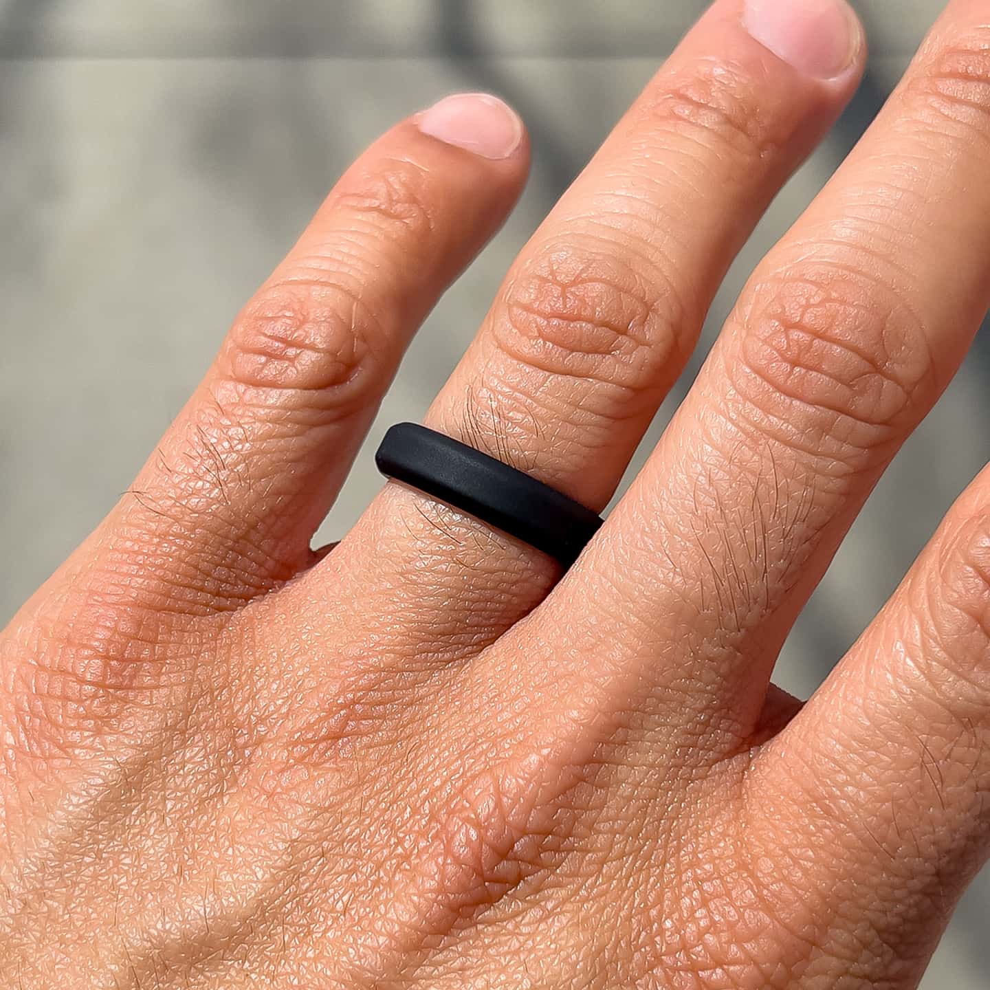 slim black silicone unisex band shown on male model