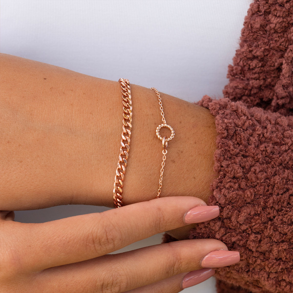 Layered rose gold bracelets on wrist