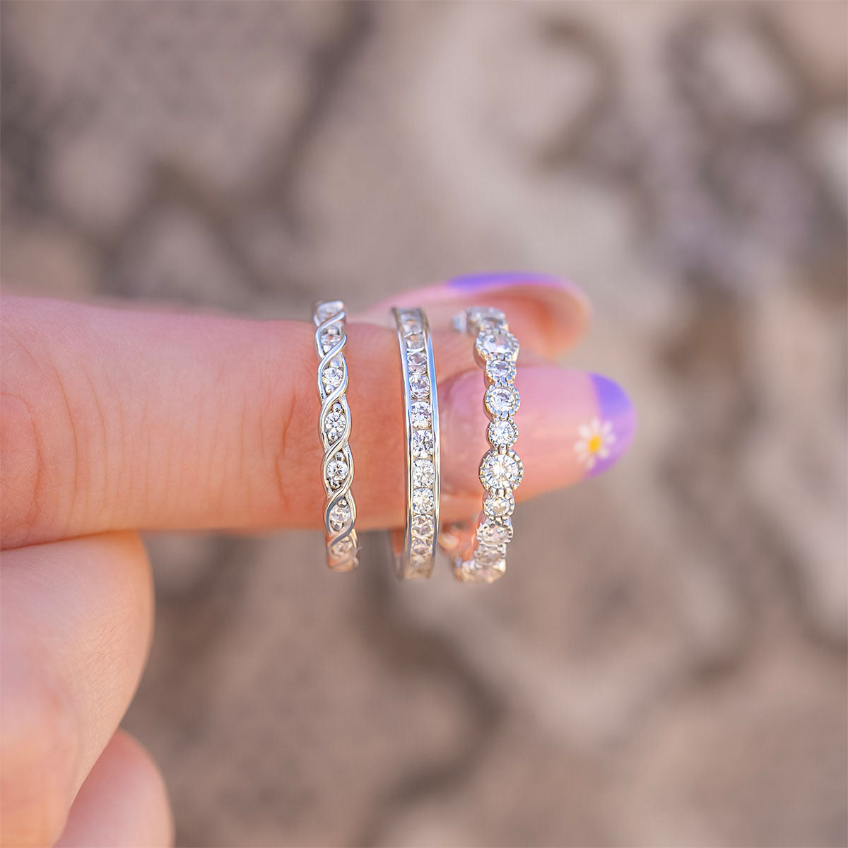 Woman holding three wedding bands