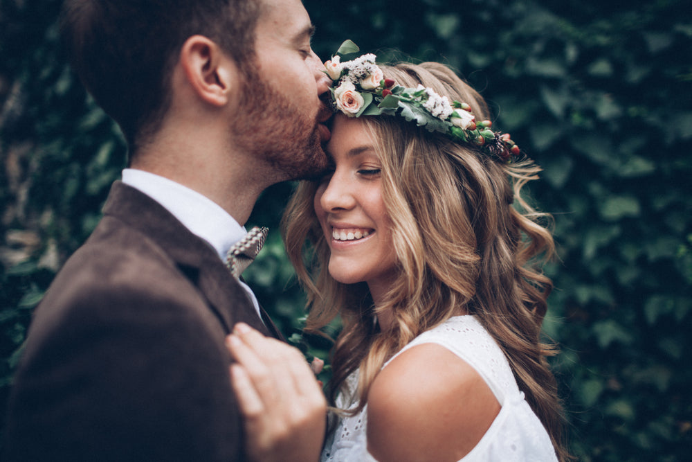 Groom kissing bride on forehead