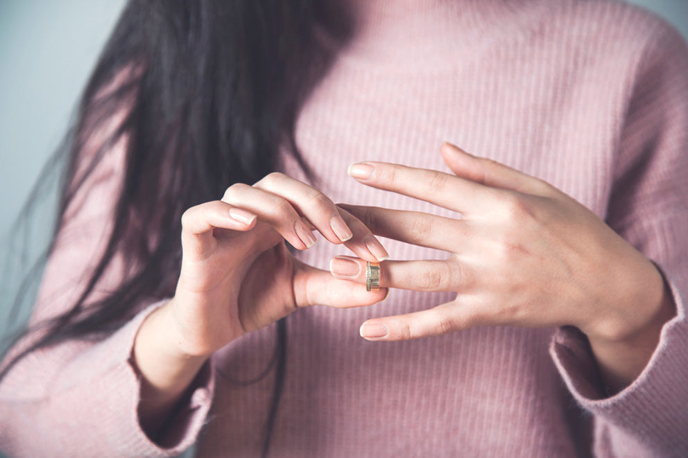 a woman taking a ring off of her finger