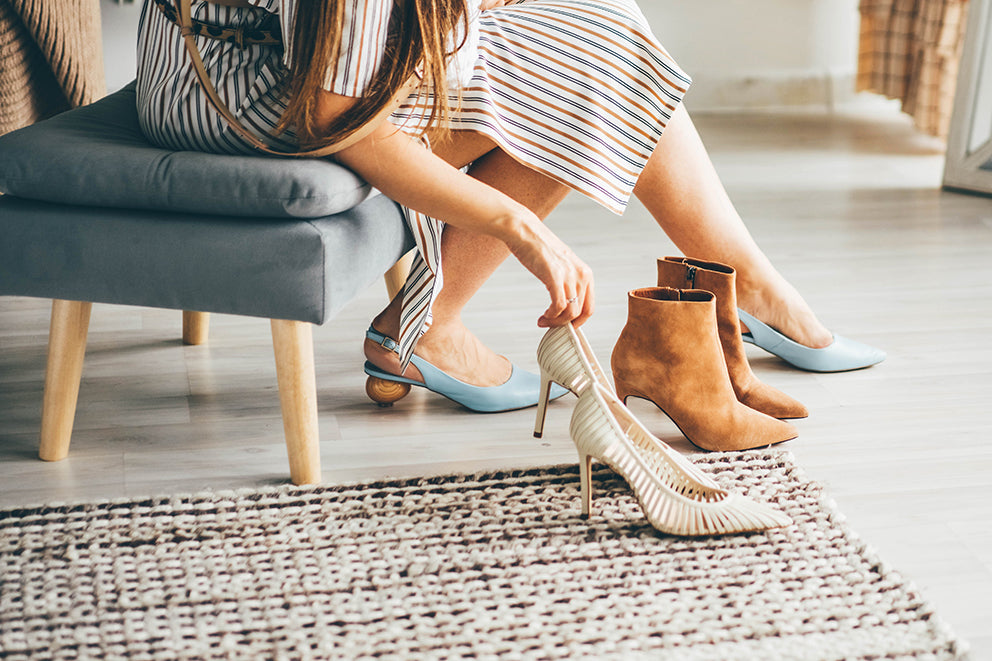 a woman trying on different pairs of shoes