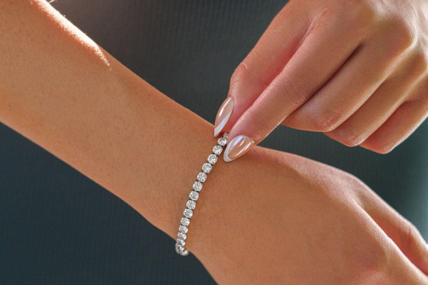 adjusting silver tennis bracelet on wrist