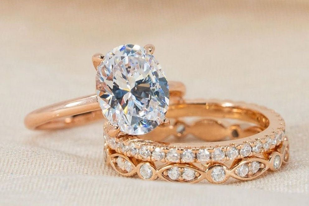 a close up of the elena engagement ring with the promise and the bella wedding bands