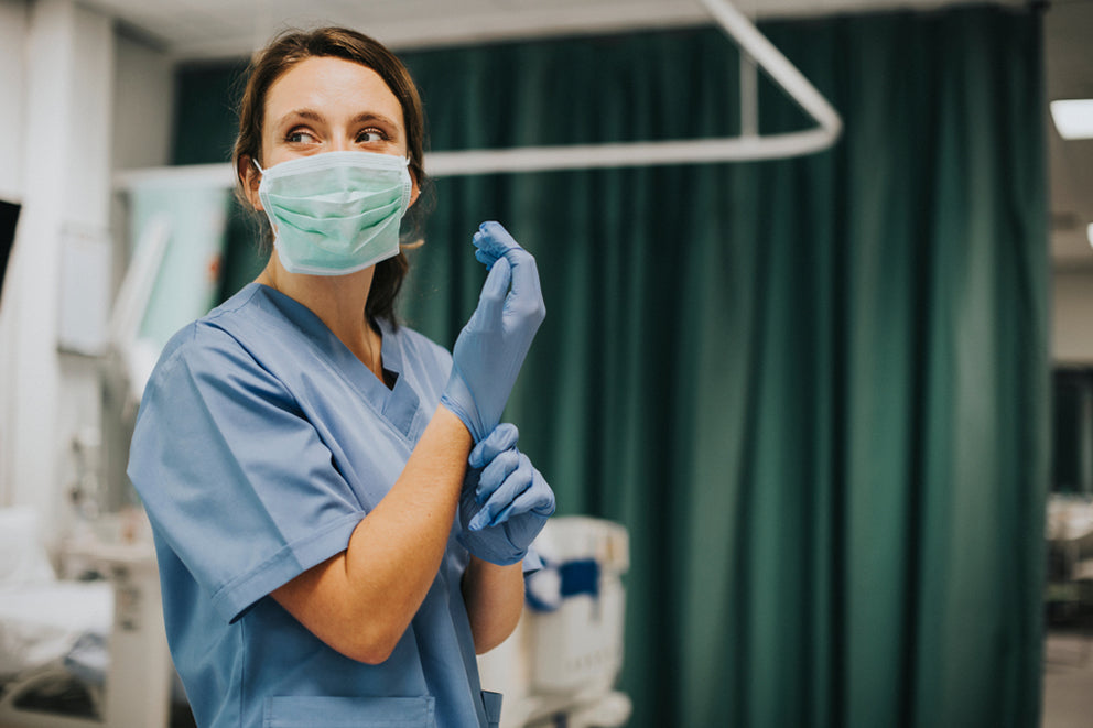 a female nurse putting on gloves