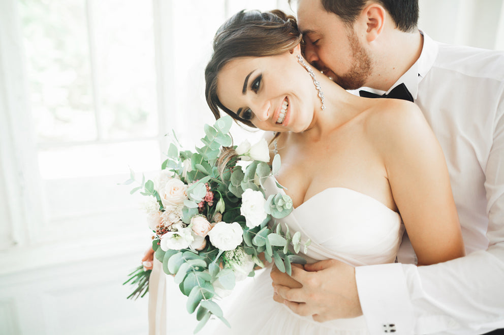 a groom hugging a bride from behind