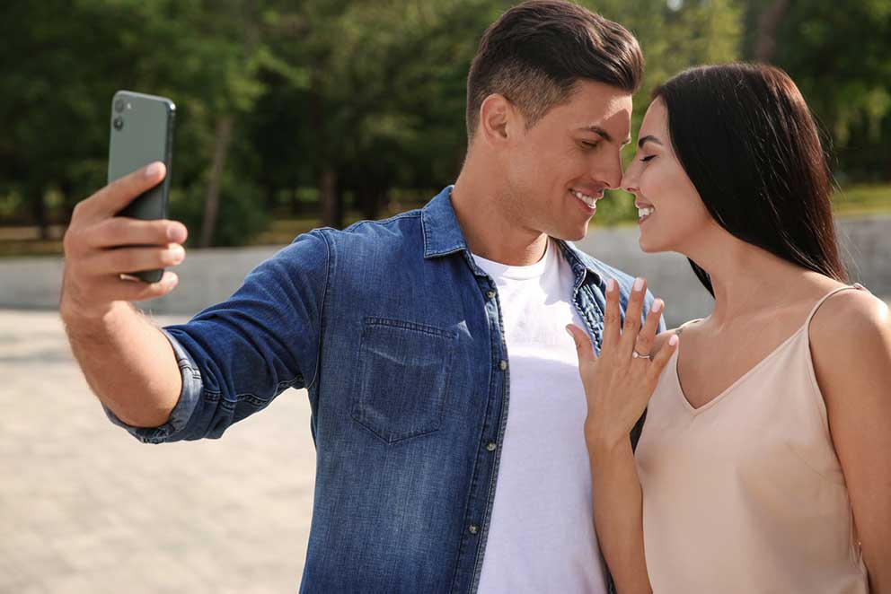 newly engaged couple take selfie