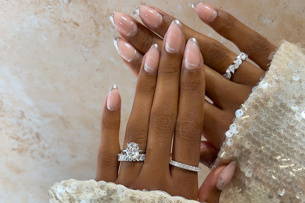 pair hands wearing silver rings