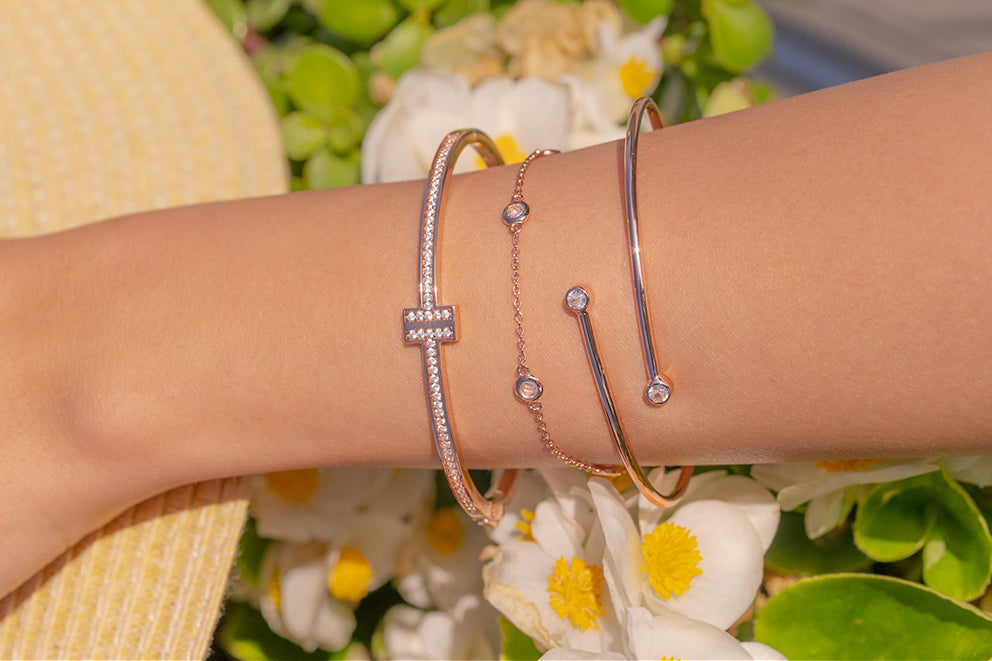 a woman wearing a set of stacked bracelets