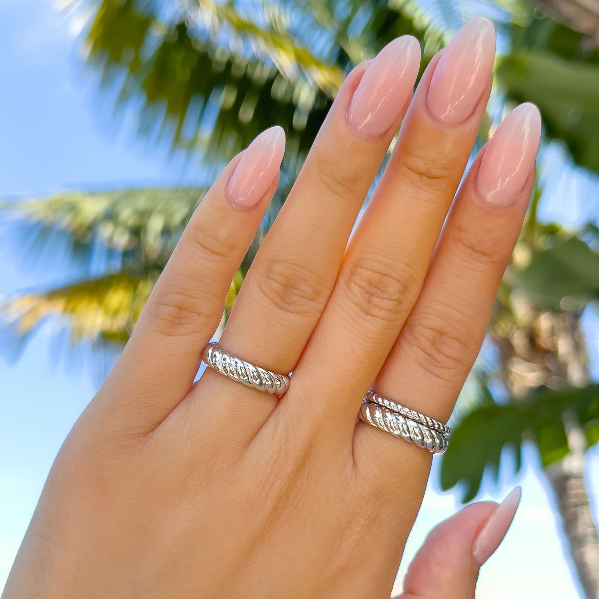 silver 3-piece ring set worn in a casual, everyday style by model with neutral nails