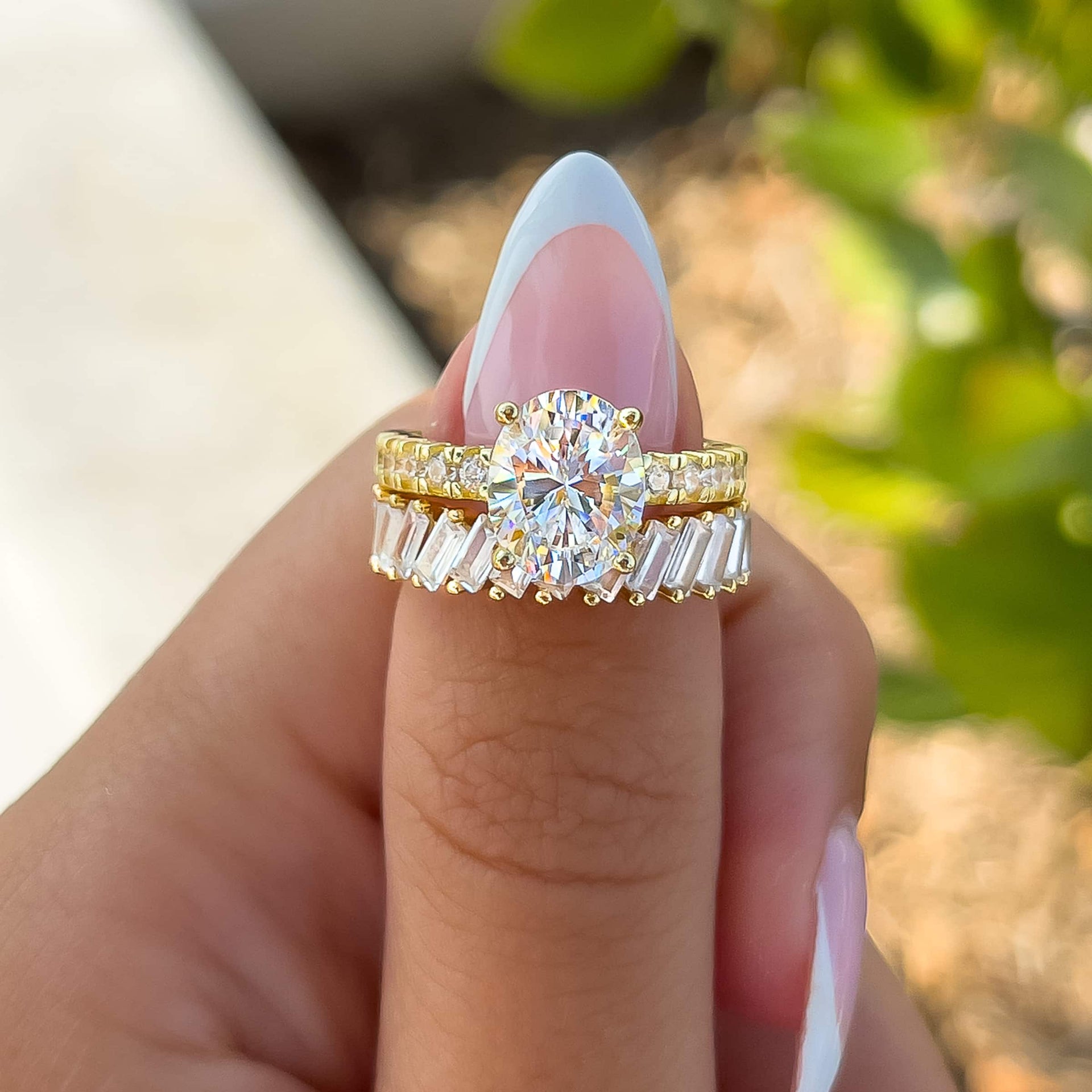 gold 3 carat oval cut engagement ring paired with gold baguette band