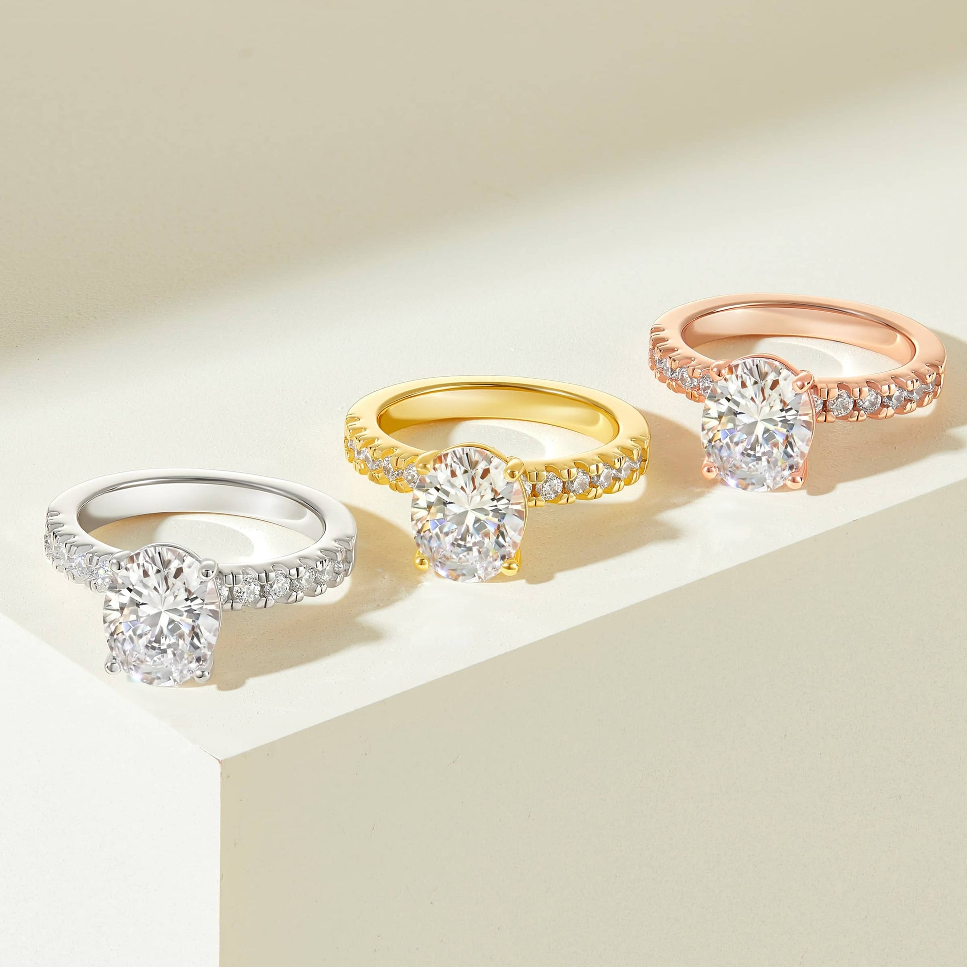 3 carat oval cut half eternity engagement ring shown in silver, gold, and rose gold