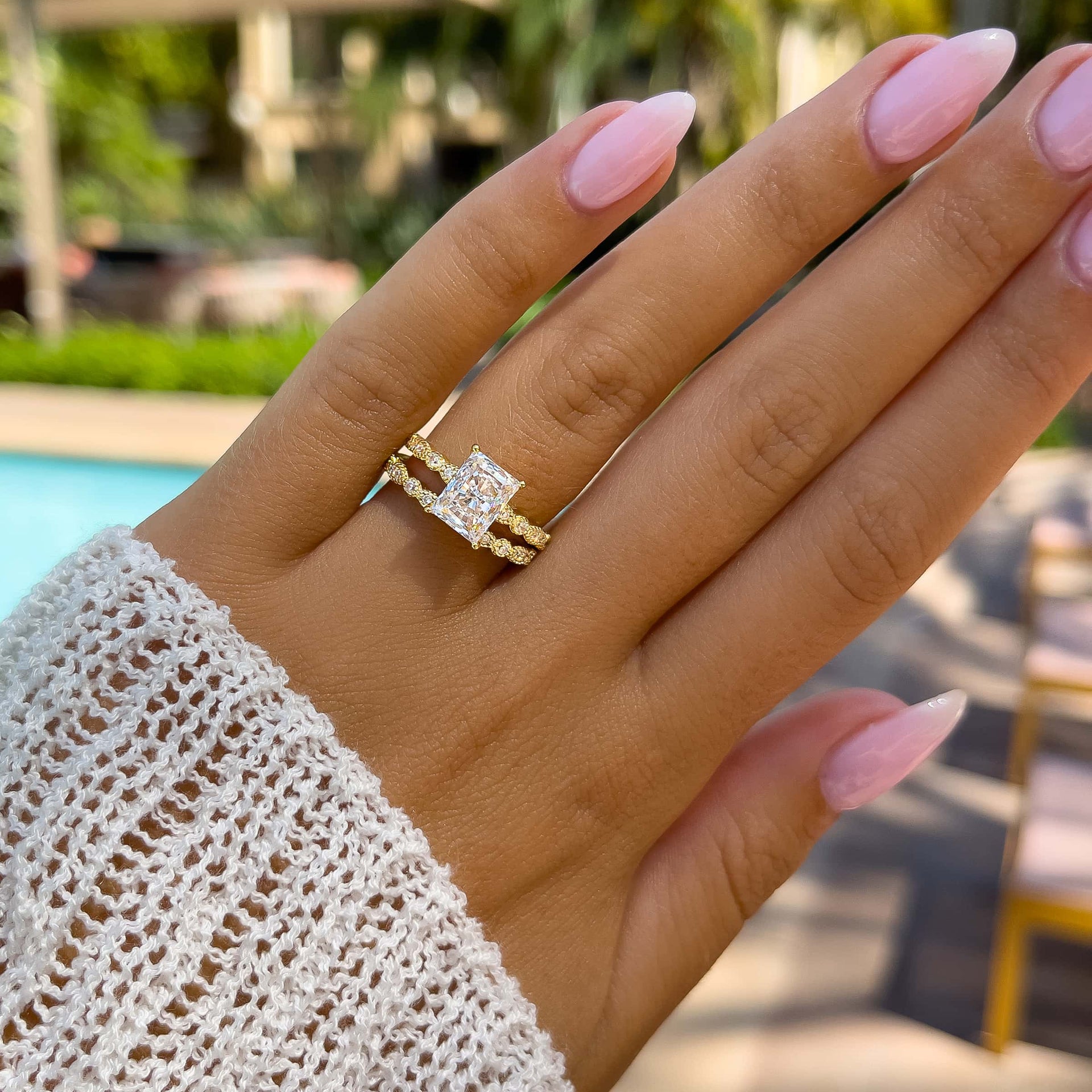 affordable gold vintage style wedding ring set on model with light pink nails and white sweater