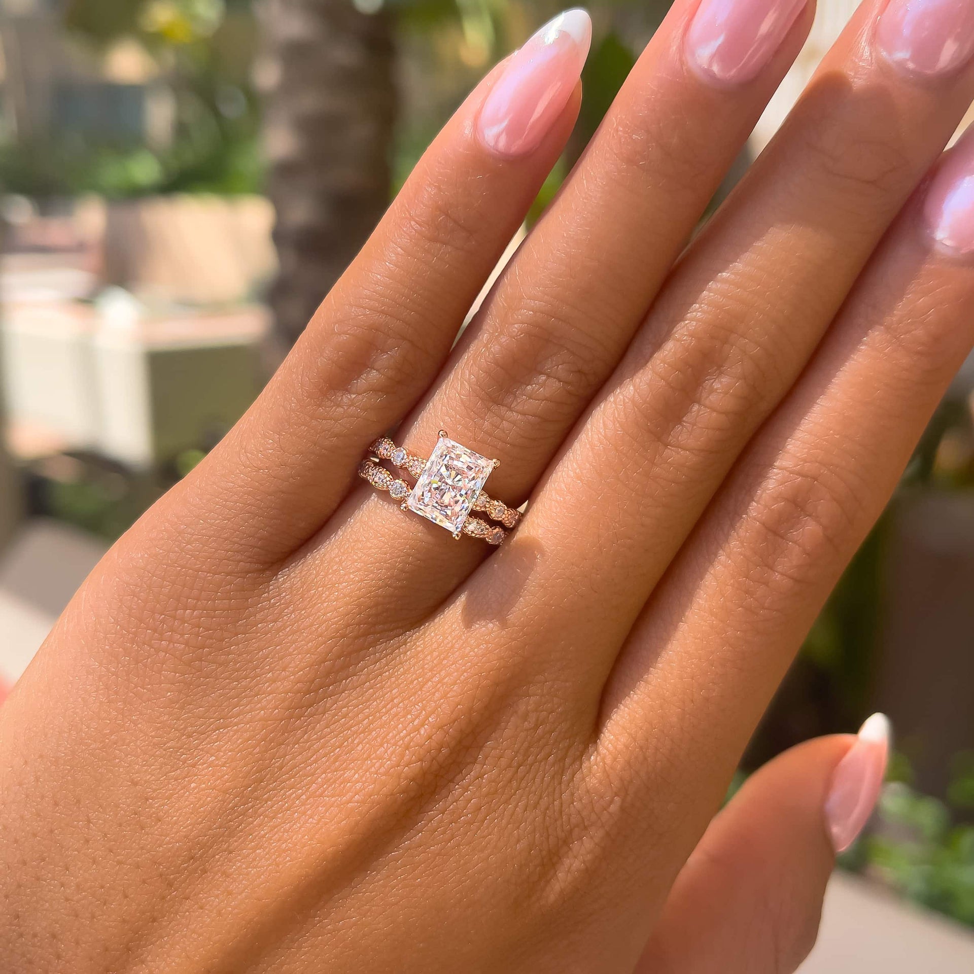 rose gold radiant cut wedding ring set on model with french tip nails