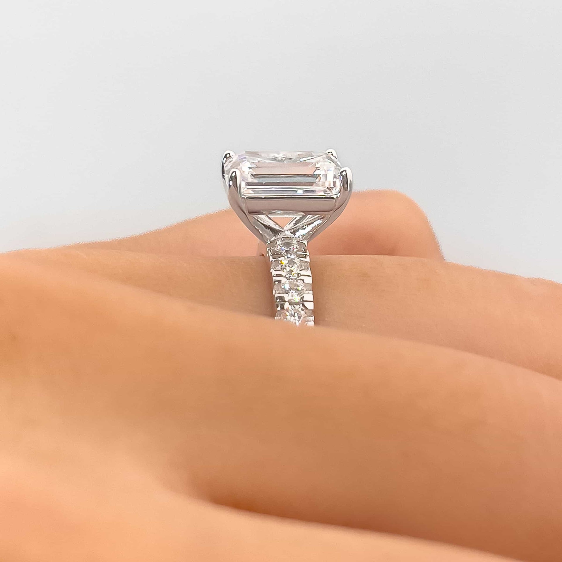 close up side setting shot view of silver emerald cut engagement ring