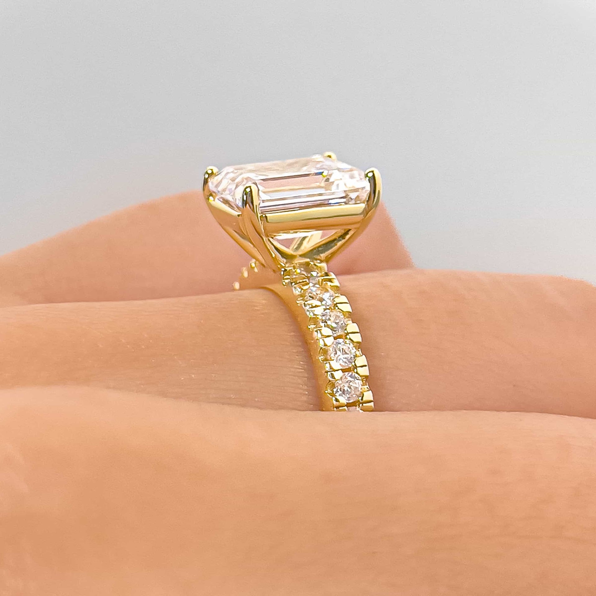 side profile of bold gold 3.75 carat emerald cut half eternity engagement ring