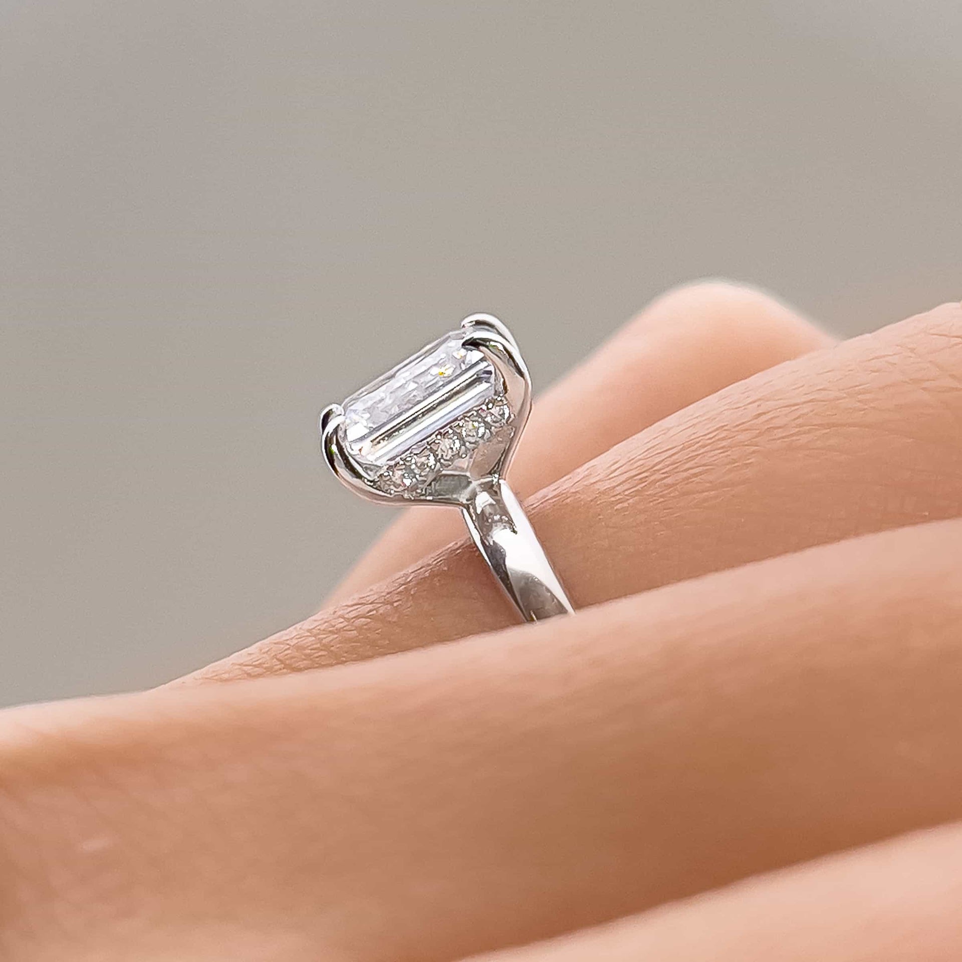 setting shot close up of silver emerald cut solitaire engagement ring