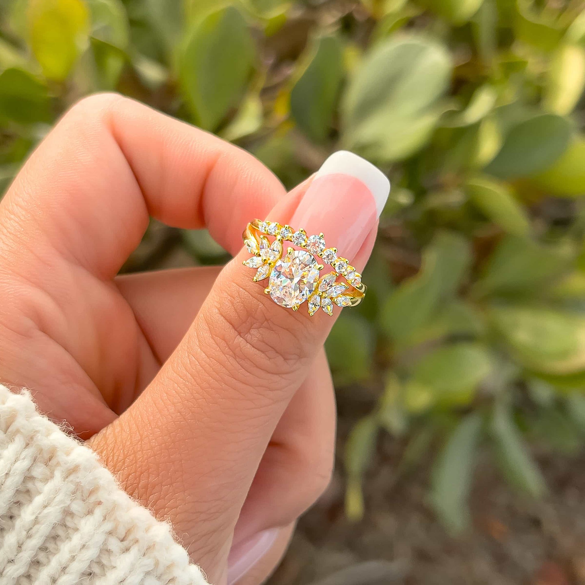 stunning gold vintage 1 carat oval cut split shank engagement ring on model with french tip nails and cream knit sweater