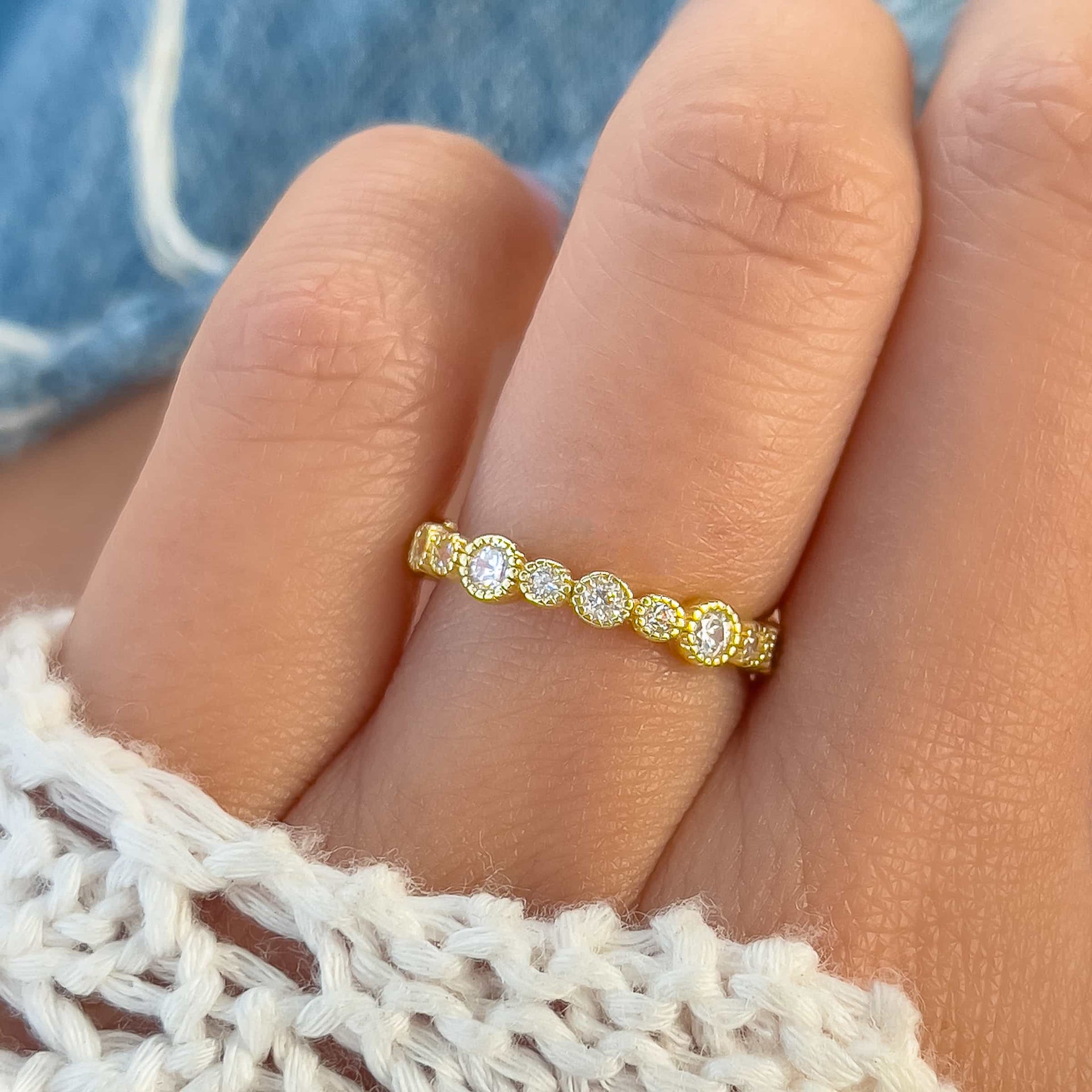 dainty and unique gold eternity band on model with white sweater