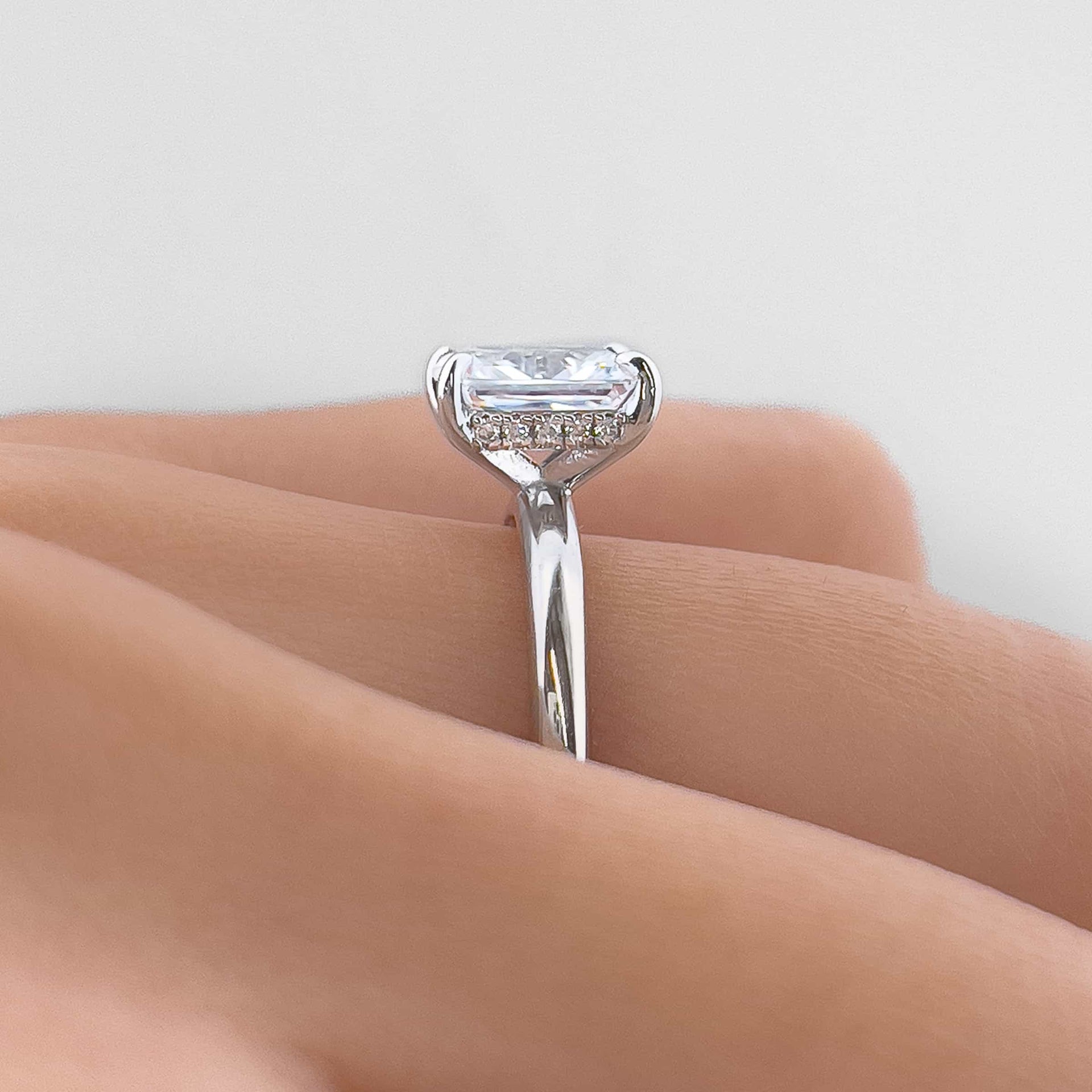 Setting shot of silver 1.5 carat radiant cut solitaire engagement ring with hidden halo