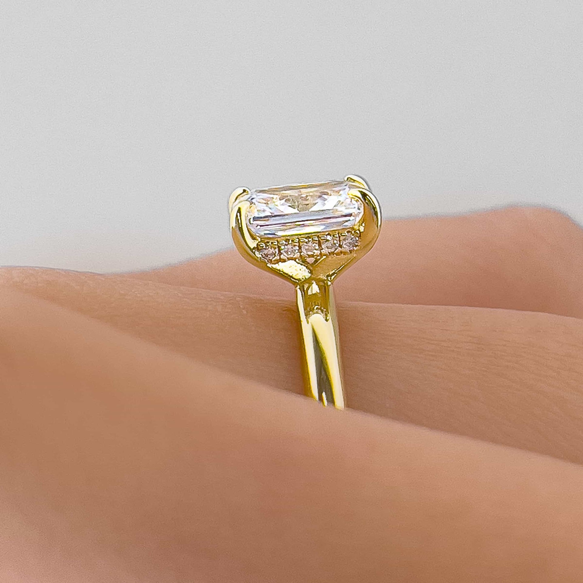 Setting shot of gold 1.5 carat radiant cut solitaire engagement ring with hidden halo