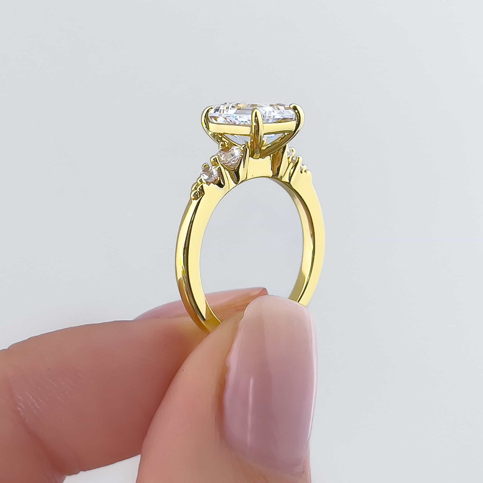 side shot of gold 1.5 carat emerald cut engagement ring