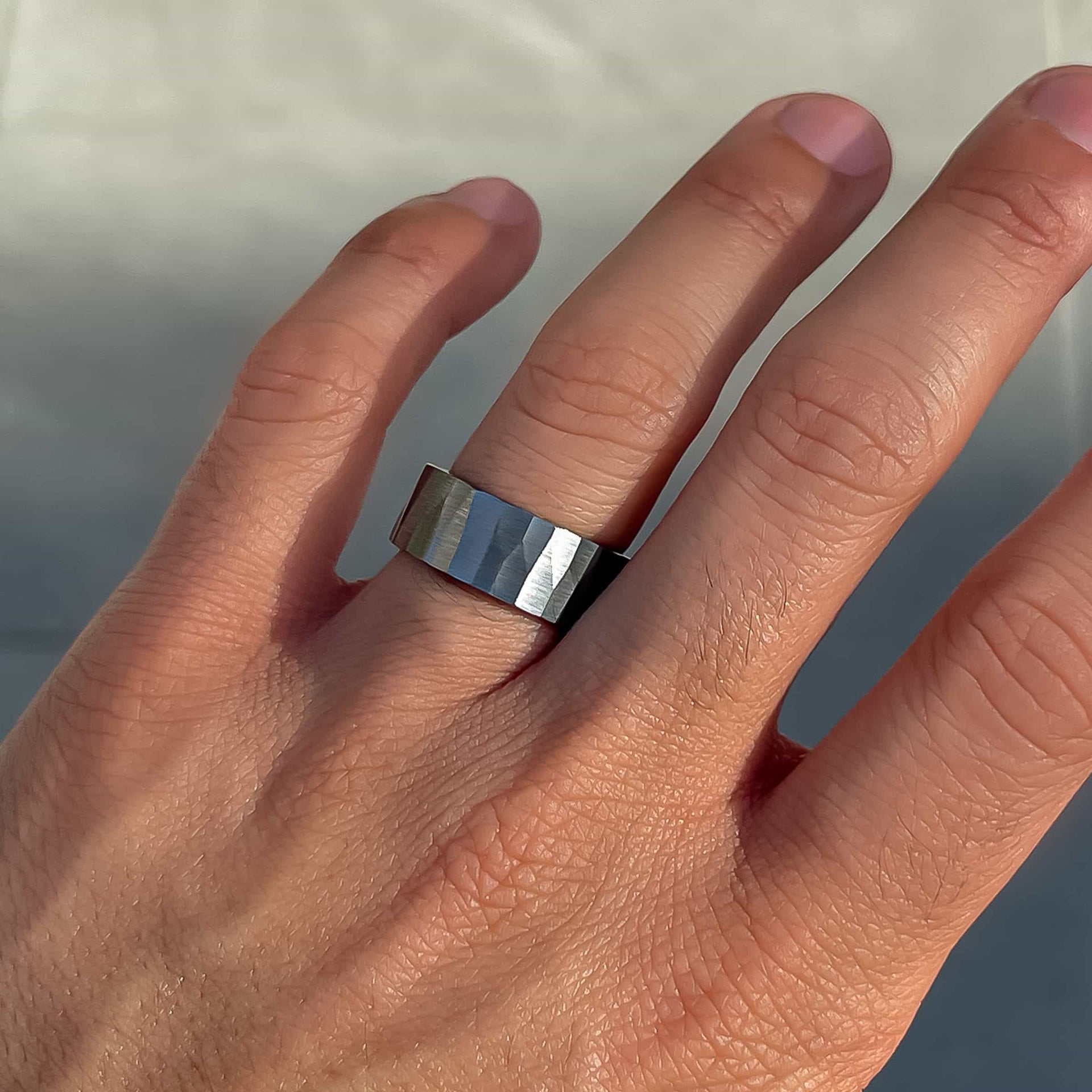 unique ridge-like silver men's wedding band on male model