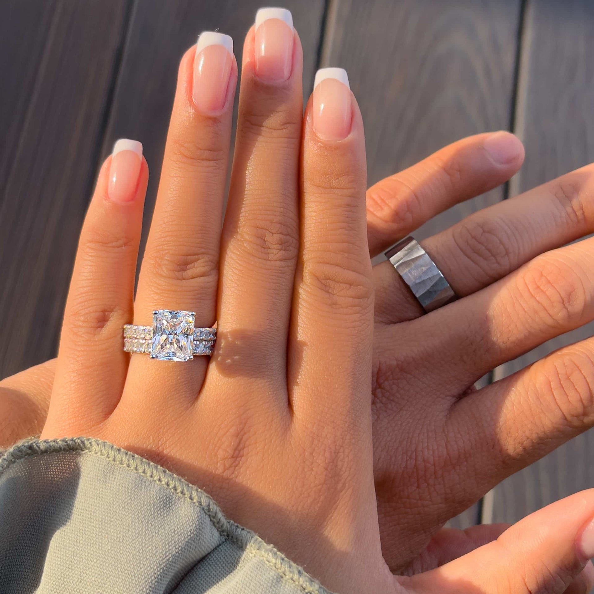 a gorgeous silver his and hers wedding ring set modeled by a male and female model