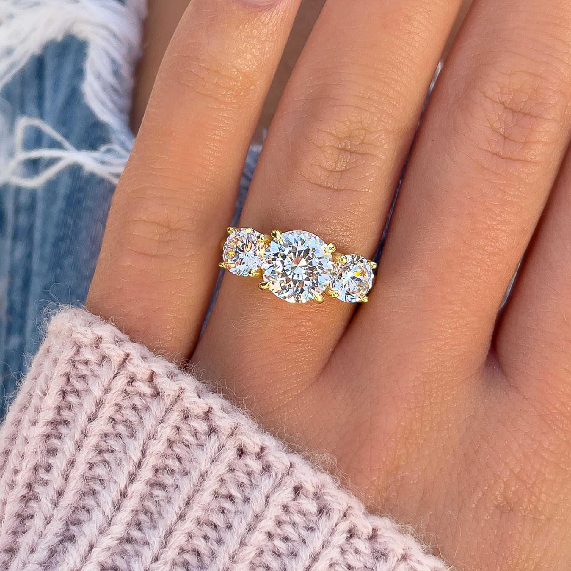 stunning trinity 2ct gold round cut engagement ring on model's hand