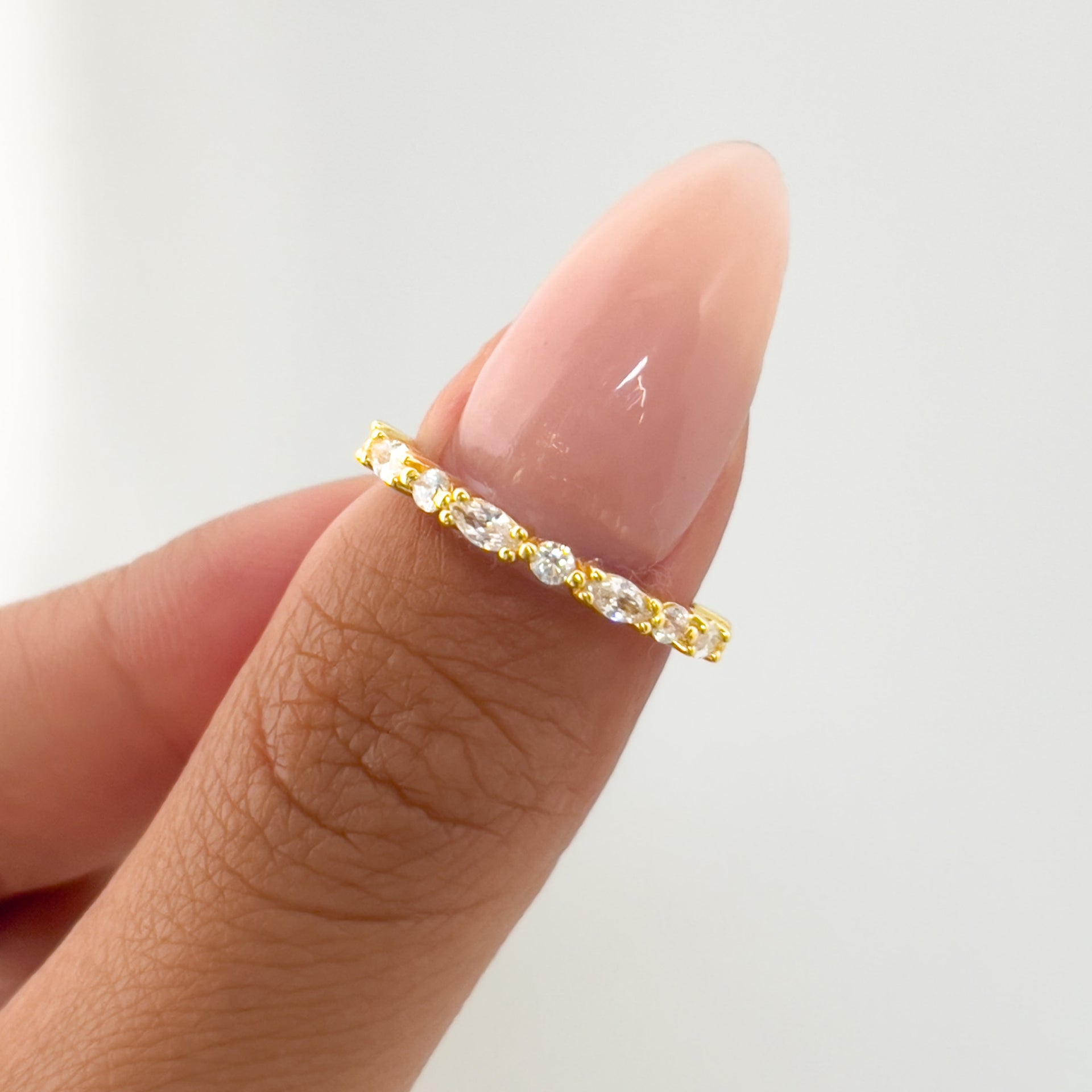 gold mixed cut wedding band on model with neutral nails