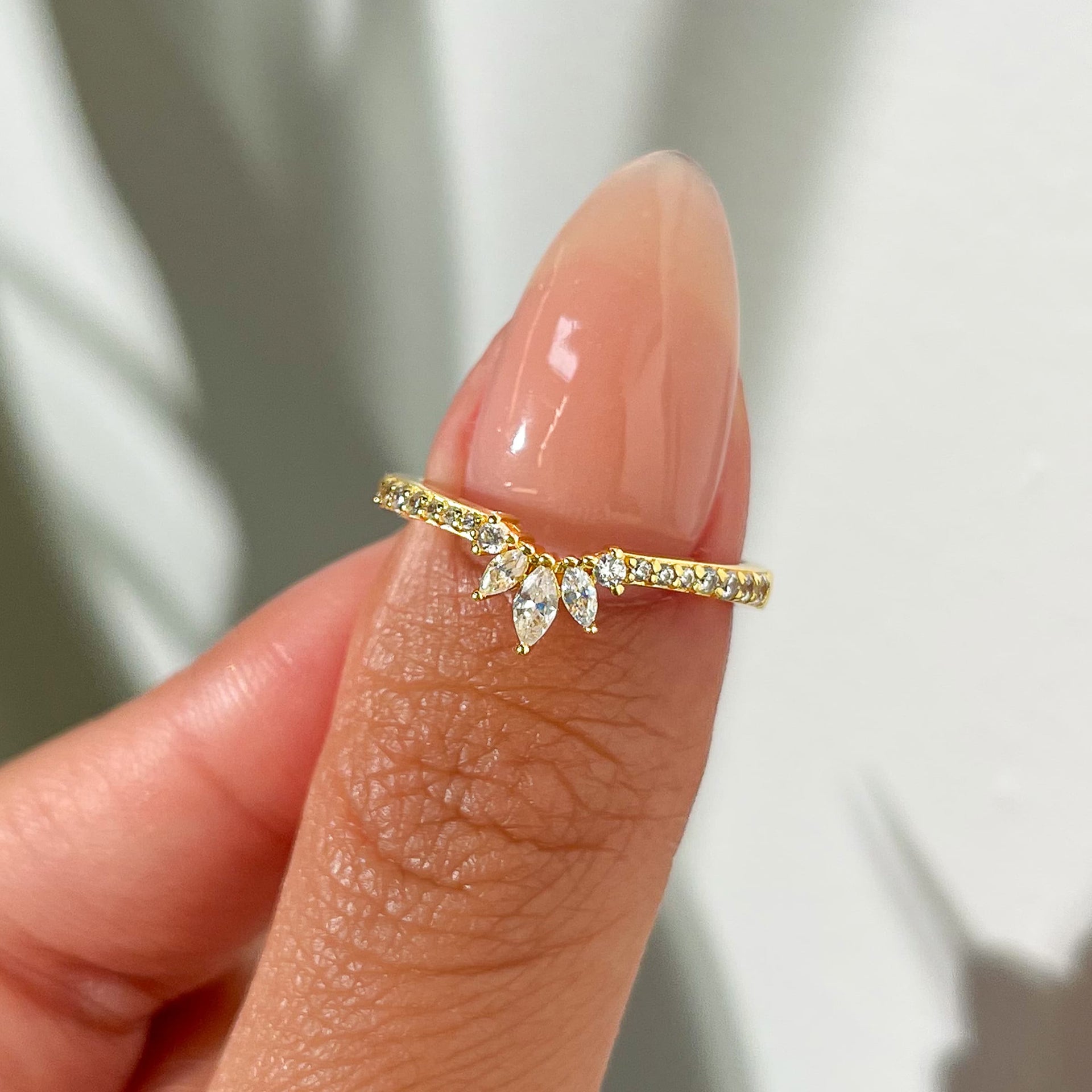 Affordable gold vintage half eternity wedding band held by model with neutral nails