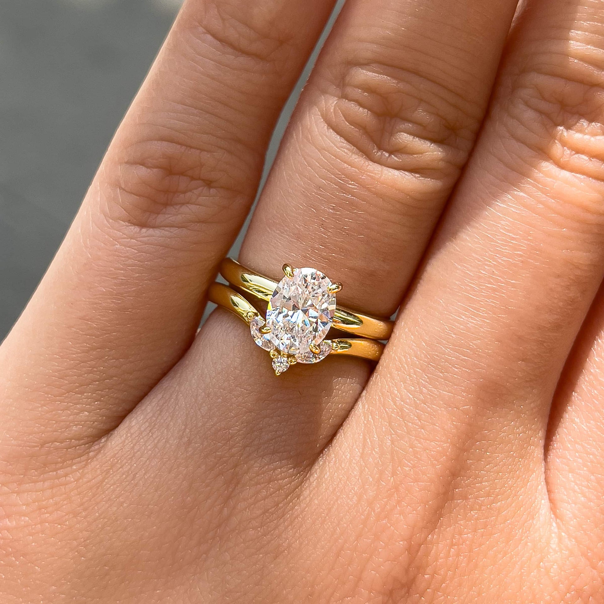 gold wedding set with petite oval cut solitaire ring and vintage chevron wedding band worn by model