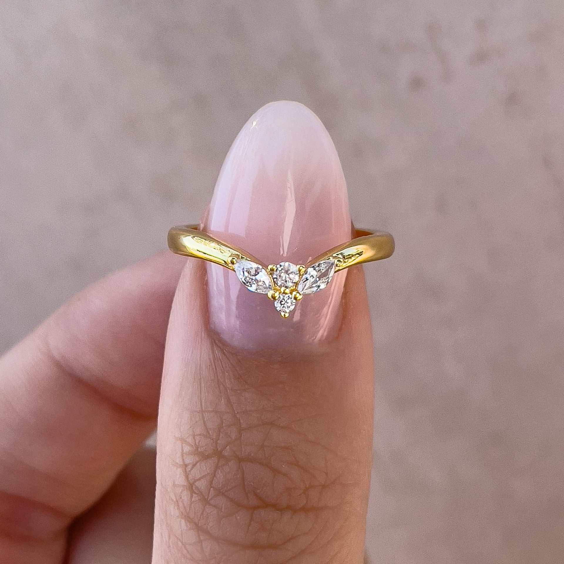 gold vintage style chevron wedding band on model with neutral nails