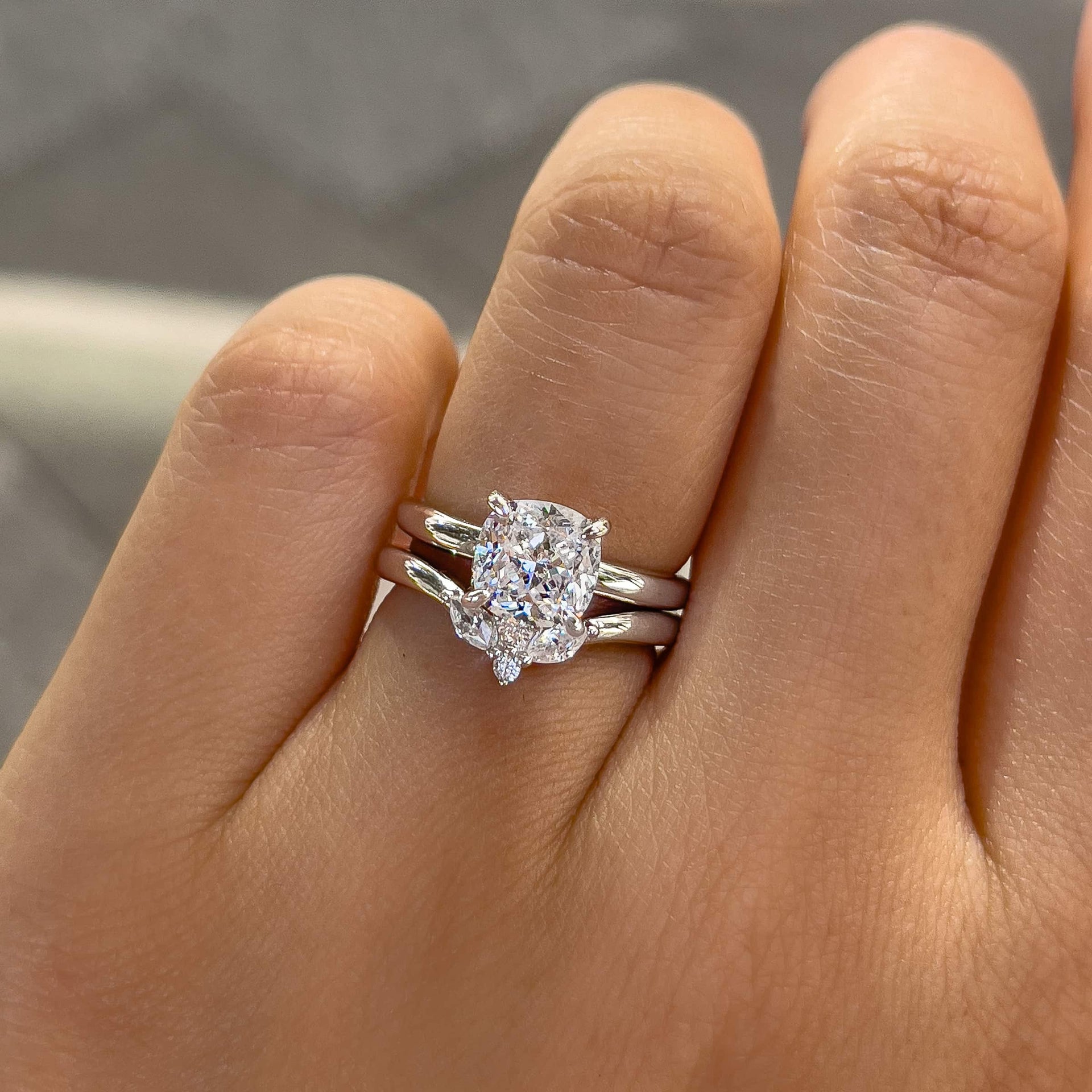 gorgeous silver wedding set made up of a petite cushion cut solitaire engagement ring and simple, vintage chevron wedding band