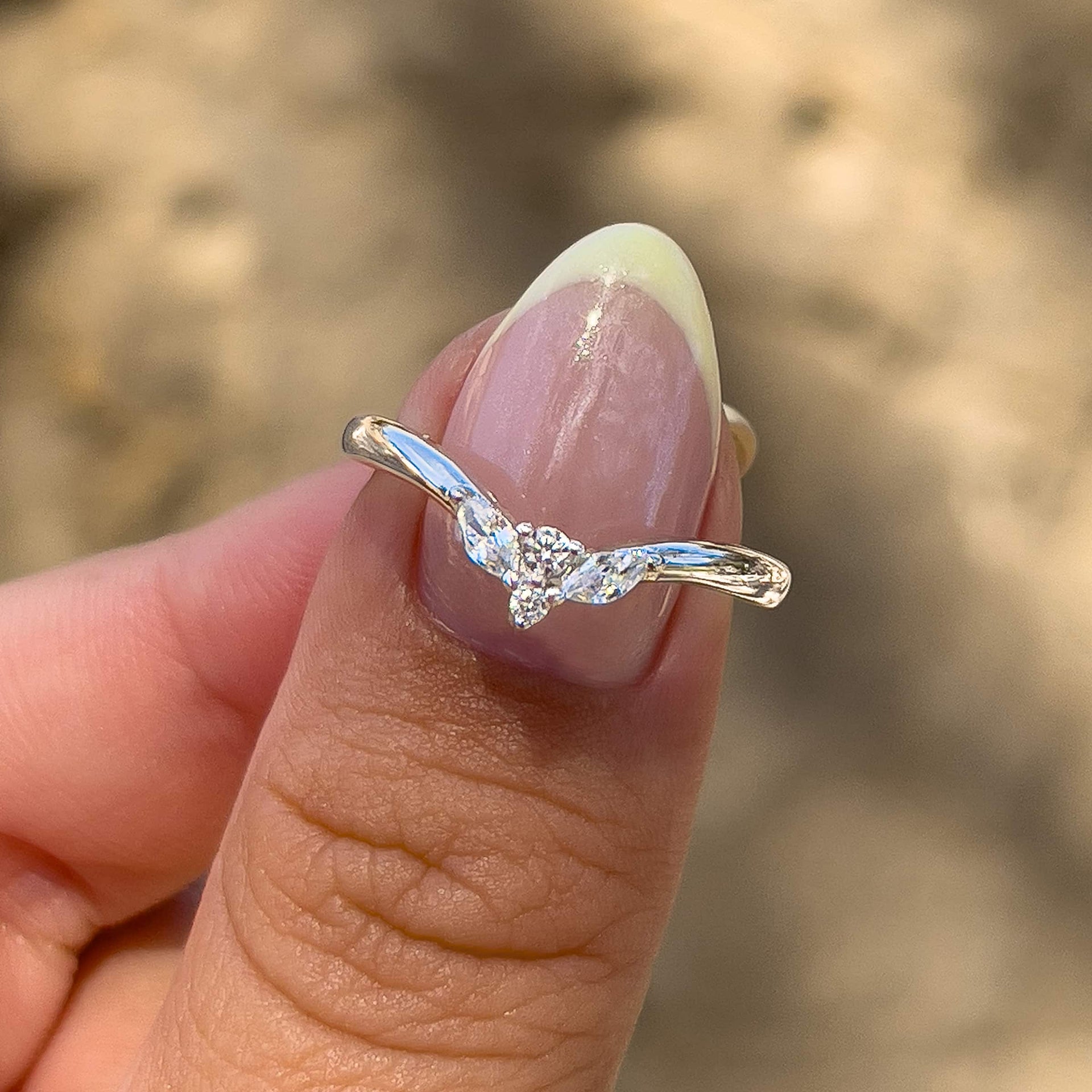 silver vintage style chevron wedding band on model with yellow chrome french tip nails