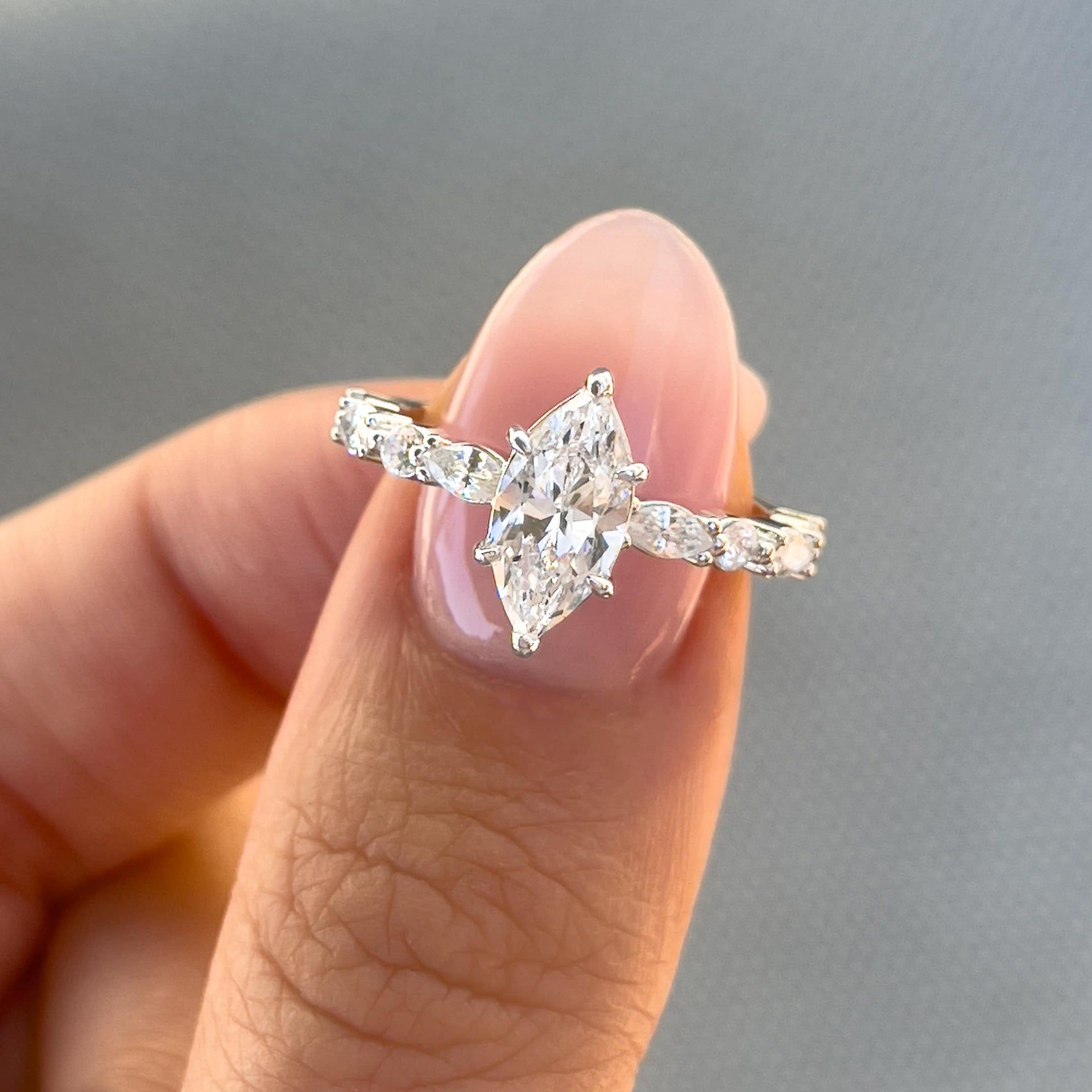 affordable 1 carat silver vintage engagement ring held by model with light pink nails