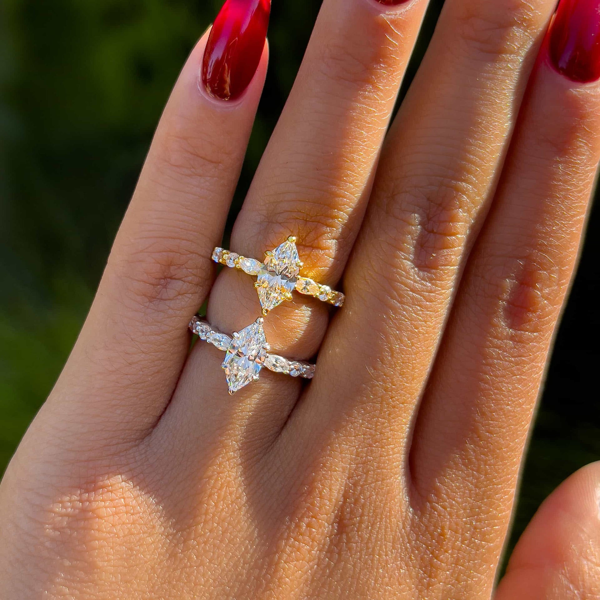 vintage 1 carat marquise cut half eternity style engagement ring shown in gold and silver on model with deep red nails