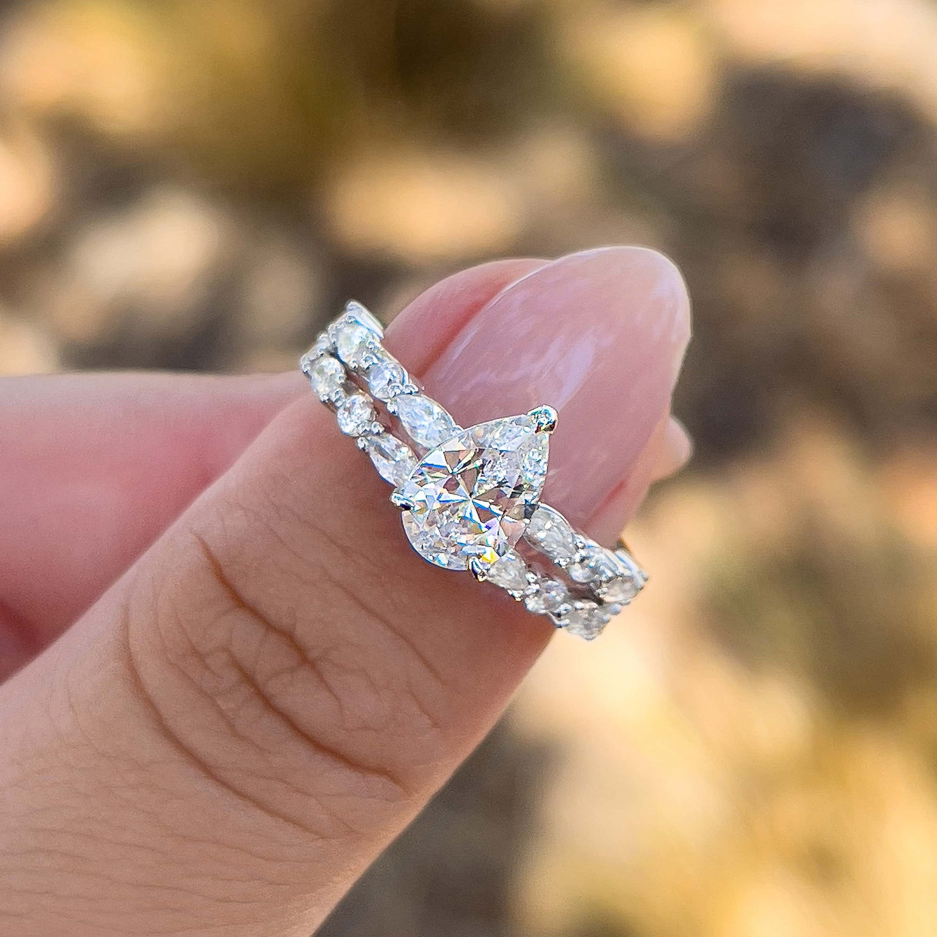 vintage silver half eternity pear cut wedding ring set held by model with neutral nails