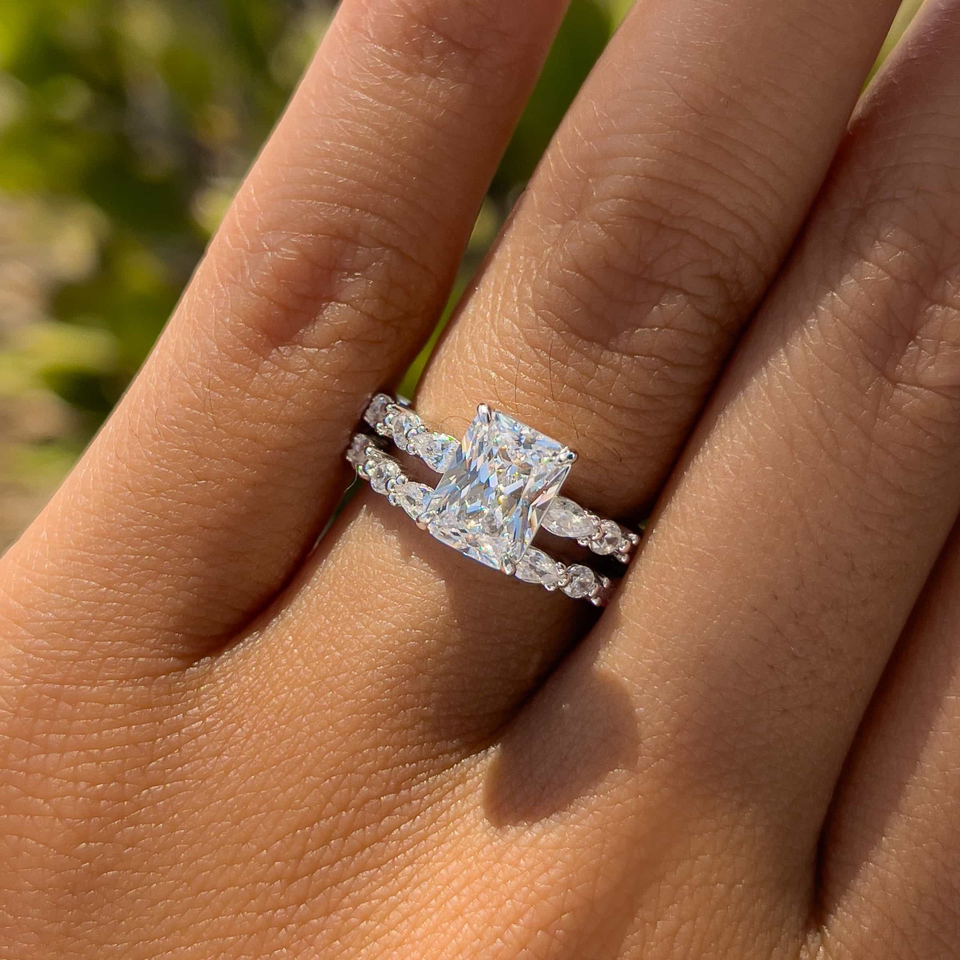 bold silver half eternity radiant cut wedding ring set worn by female model