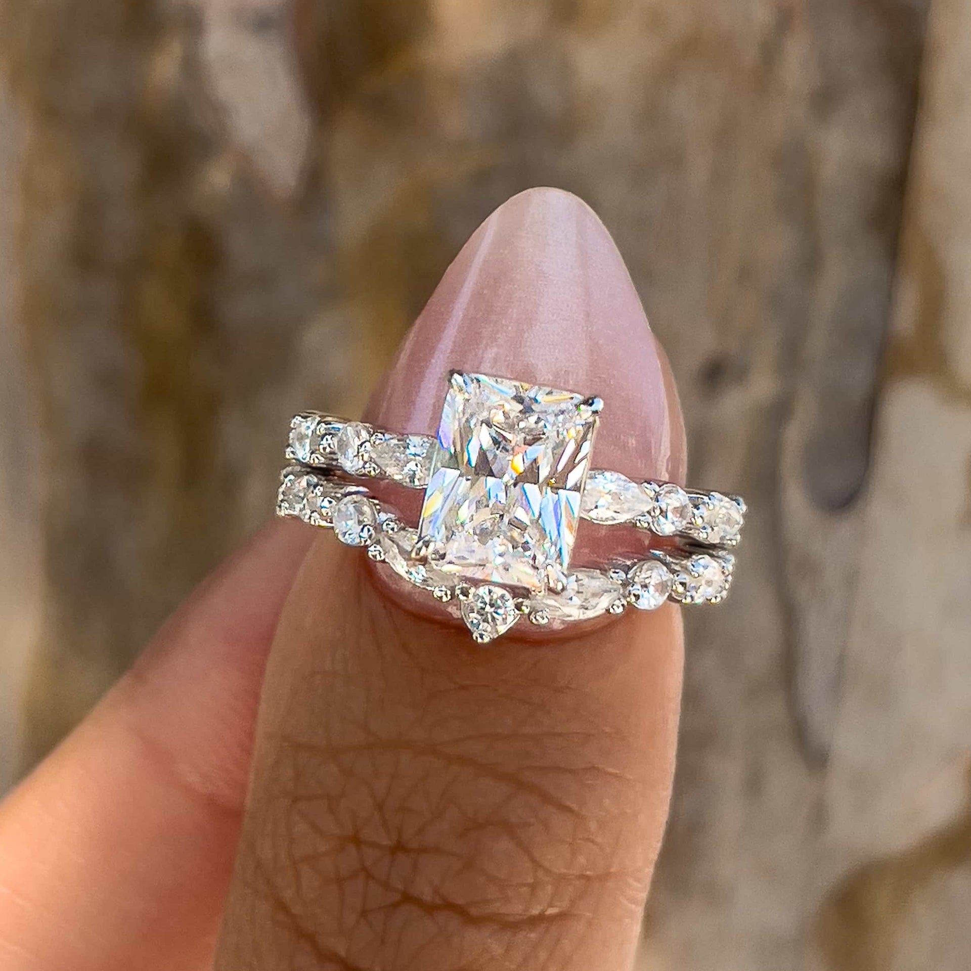 stunning 2 carat vintage radiant cut half eternity ring held by model with pink nails