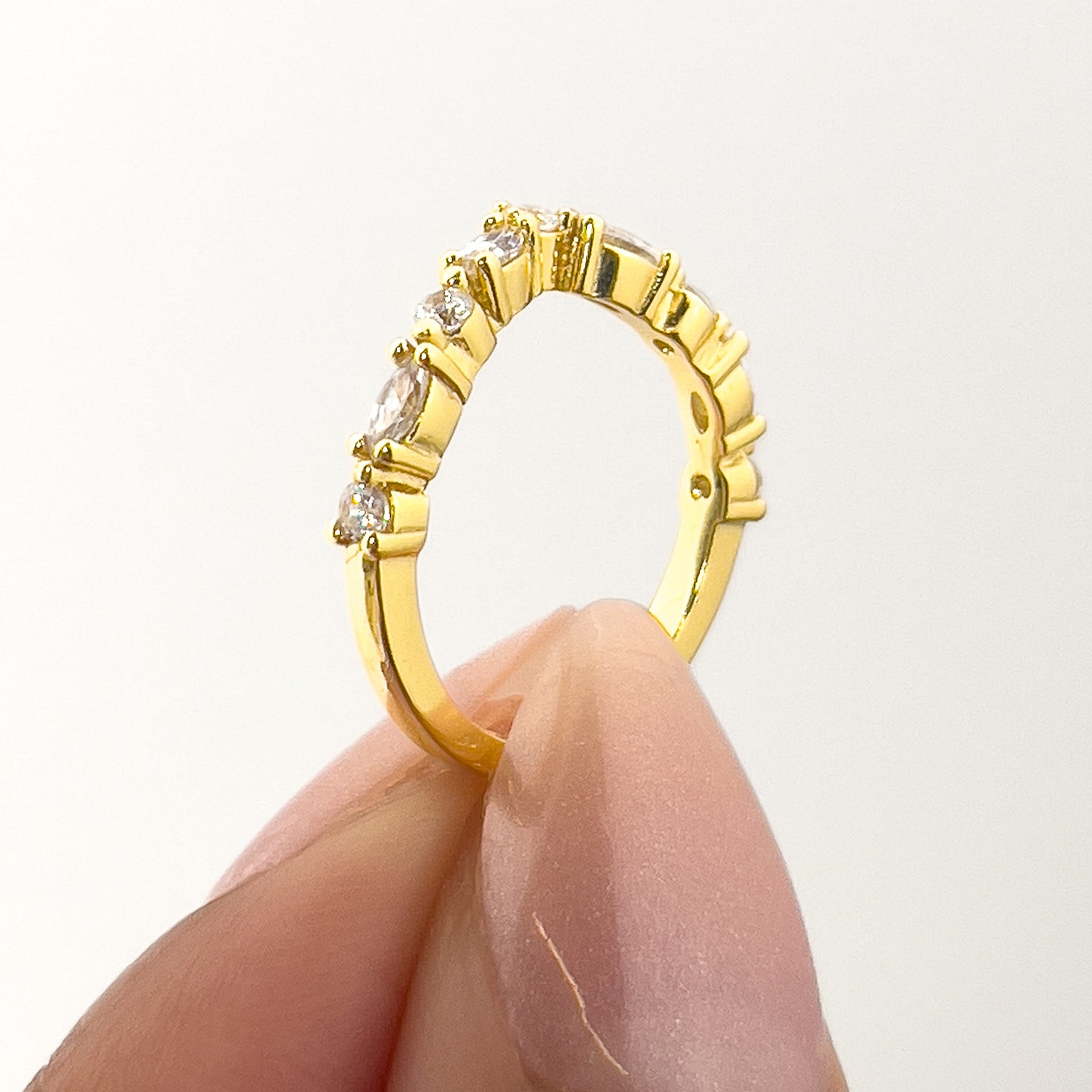 setting shot of a vintage chevron half eternity band held by model with neutral nails
