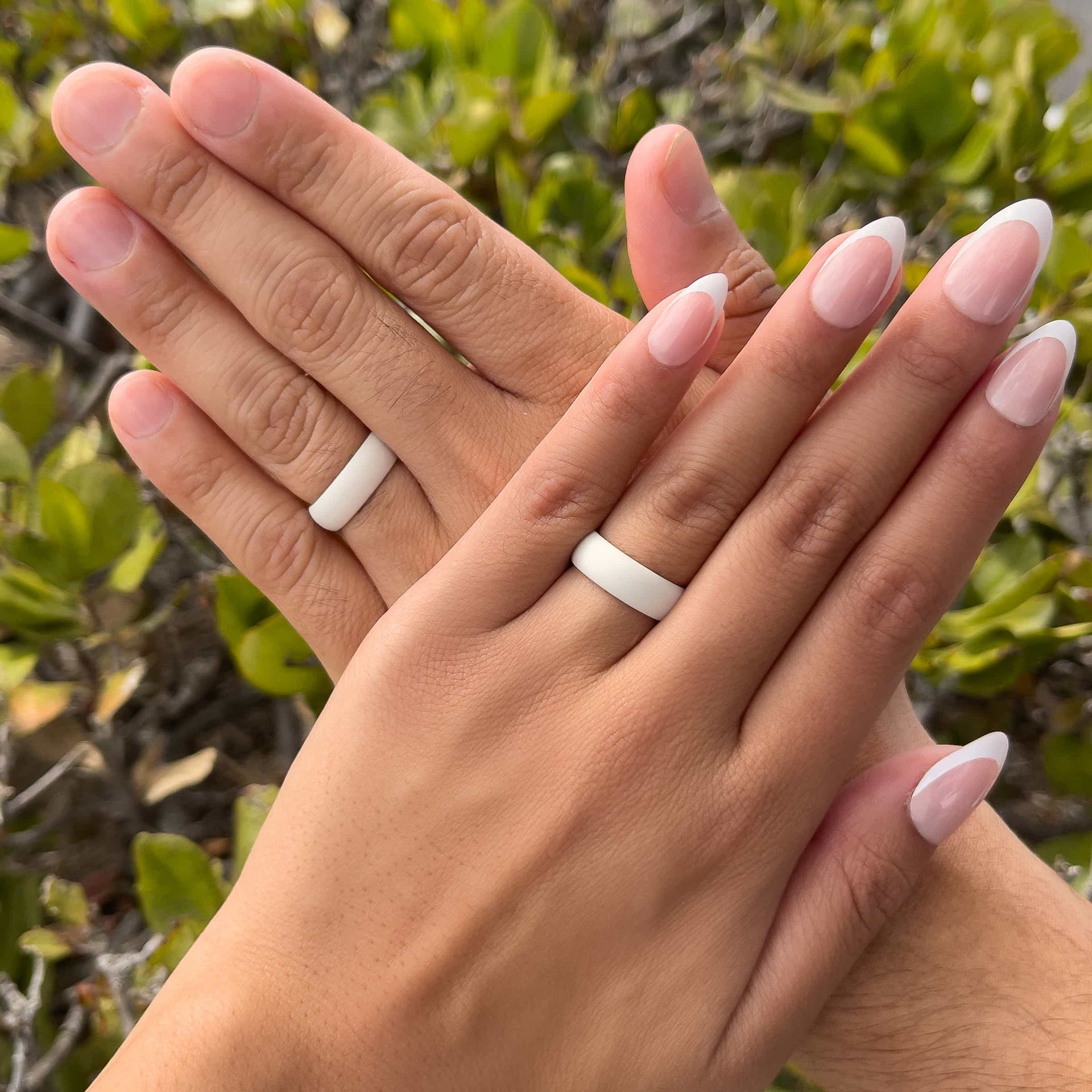 unisex neutral tan silicone band worn by both a male and female model in front of greenery