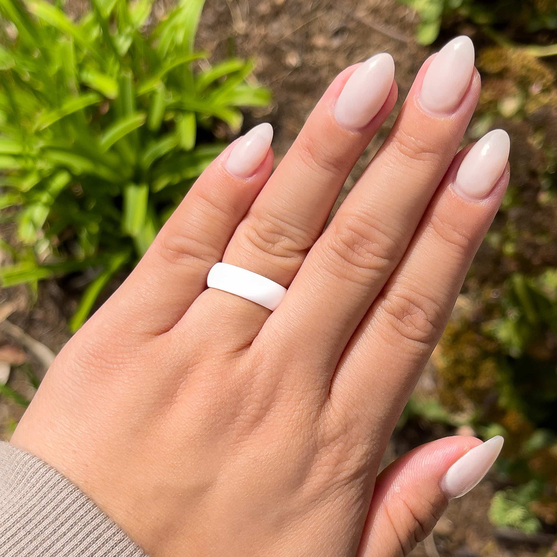 white silicone alternative band worn by model with neutral nails in an outdoor setting