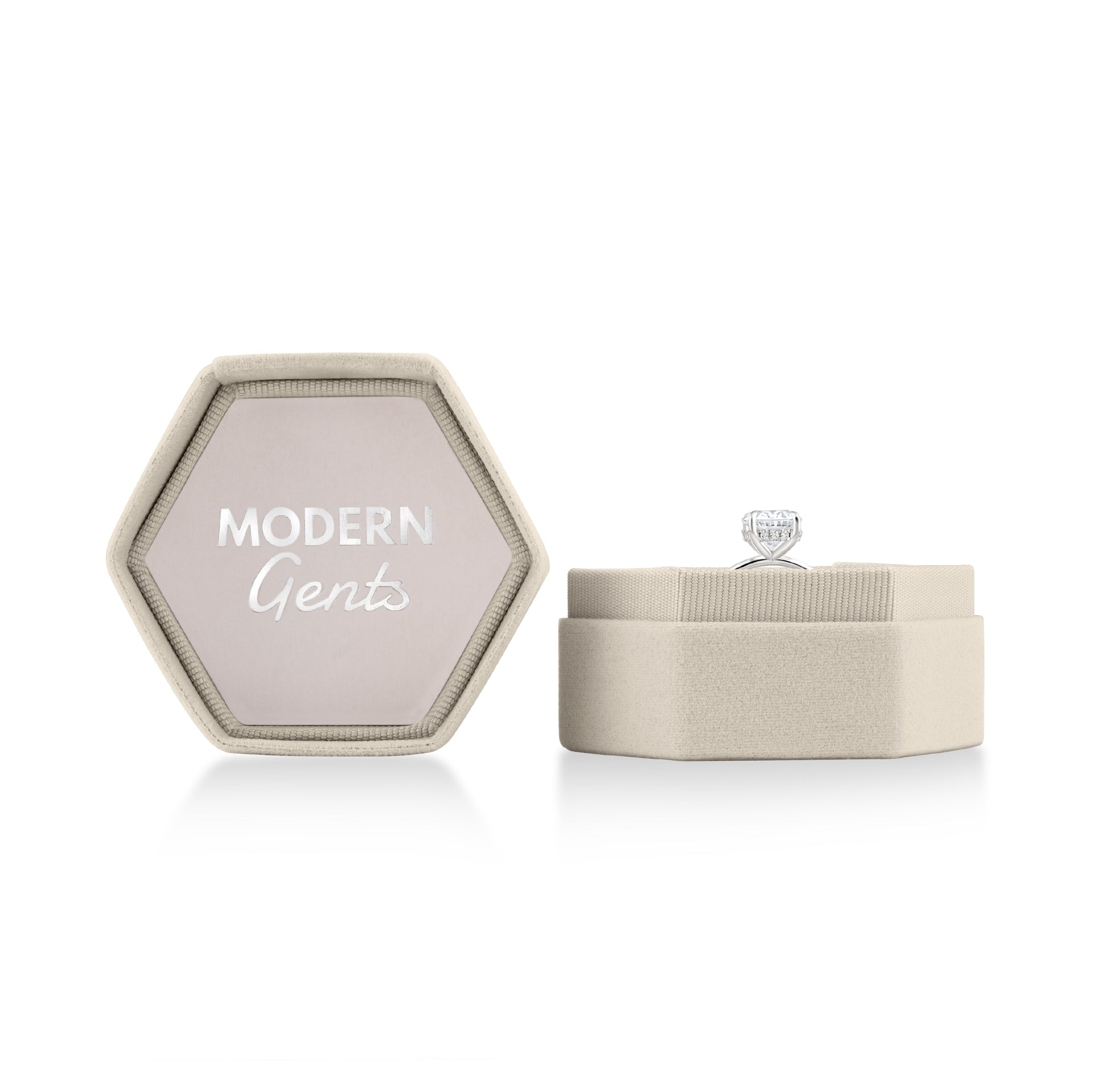 Open stone velvet hexagon box with silver Modern Gents logo on the inside of the lid & a ring sitting in the bottom portion of the box on a white background 